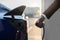 Close up cropped image of unrecognizable afro american man in business wear, holding electricity cable for electric