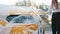 Close up cropped image of young caucasian woman's hand with yellow sponge washing hood and mirror of her car at self