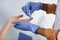 Close up cropped photo of hands of a female black nurse taking a patient& x27;s blood sample, using painless scarifier.