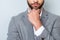 Close up cropped photo of minded young man in formalwear touching his chin