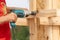 Close up cropped photo of workmen using drill holding plank board on wooden pole construction or column formwork