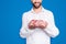 Close up cropped portrait of cheerful half face butcher demonstrate fresh meat in his arms, isolated on grey background