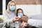 Close up cropped shot of blurred mother and teen daughter in medical masks, sick at home. Middle aged mother taking a