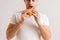 Close-up cropped shot of hunger young man holding eating delicious burger on white isolated background.