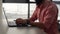 Close-up cropped shot of unrecognizable bearded businessman typing on laptop keyboard working at office desk on