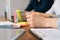 Close-up cropped shot of unrecognizable businessman sitting at table and holding pen. Corporate decision making