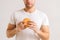 Close-up cropped shot of unrecognizable hunger young man holding in hands delicious burger on white  background.