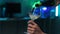 Close-up cropped shot of unrecognizable male hand pouring wine into glass on background of bokeh neon light in living