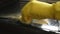 Close-up cropped shot of unrecognizable male housewife wearing rubber gloves wiping cleaning dirty dirty stove oven door