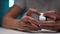 Close-up cropped shot of unrecognizable man removing protective film from new action camera body during unpacking.