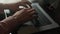 Close-up cropped shot of unrecognizable young man opening cover of new Apple MacBook Pro 16 inch laptop and starting