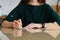 Close-up cropped shot of unrecognizable young woman writing handwritten letter sitting at table at home, selective focus