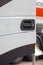 Close up cropped vertical photo of black door handle on new bright white cabin truck