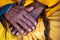 Close up of the crossed wrinkle hands of an elder grandmother nepalese woman.