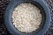 Close-up with crushed whole oats. In stone mortar.