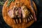 Close up of crusted lamb ribs cutlets with bone rar medium roasted on wooden cutting board with knife and herbs. Top view. Meat