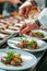 Close-up of a culinary artist using tweezers for precision in plating.