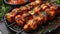 Close-Up Culinary Delight: Top View of Chicken Kebab on a Black Plate