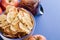 Close-up  cup with apple chips, fresh apples and jar of apple jam and metallic spoon on blue background