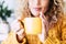 Close up on cup with tea or coffe drink inside and beautiful defocused woman in background - concept of relax and healthy