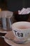 A close-up of a cup of tea next to the kettle in bar