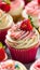 a close-up of a cupcake with vanilla and strawberry frosting and sprinkles