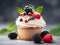 Close up of a cupcake with whipped cream and berries on table with grey blurred background. Creamy vanilla cupcake decorated with