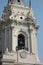 Close up of the curch bell above a dirty and unreadable clock