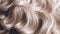 Close-up of curly blonde hair strands, beauty and fashion concept. Macro shot of female blond hair strands, top view. Hair care