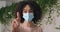 Close-up curly responsible sick girl afro american woman teenager wears medical protective mask on female face suffering