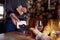 Close Up Of Customer Paying In Hotel Restaurant Using Contactless Card Reader