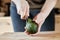 Close up cut avocado knife into hand at home step 2