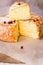 Close up of cut slice of French or German soft cheese with orange rind with mold, creamy texture, red pepper corns