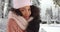 Close up of cute black female in cozy hat and sweater shivering in snowy forest