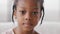 Close-up cute face african kid ethnic child looking at camera indoor, portrait of alone one little girl black daughter