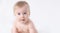 Close-up cute little adorable funny amazed caucasian blond topless baby girl or boy on white,light grey background