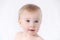 Close-up of cute little adorable funny caucasian blonde topless baby girl or boy on white, light grey background