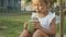 Close-up of cute little girl drinks a smoothies outdoor in slow motion