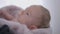 Close-up cute newborn baby girl looking away moving hands. Curios Caucasian child indoors at home. Innocence and
