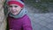 Close up of cute sad and worried little girl looking at camera and leaning on a wall