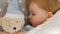 Close-up of a cute sleeping beautiful girl on a pillow with a bear