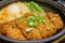 Close up of cutlet pork simmered in miso sauce on hot plate