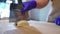 Close-up cutting dough with dough knife in slow motion on wooden tabletop. Unrecognizable Caucasian woman separating