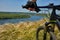 Close-up of the cyclist holding bicycle on the meadow in the countryside against beautiful landscape.