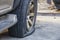 Close-up of damaged flat tire of car on parking