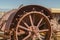 Close up of the damaged wheels of an old vintage tractor against sunny blue sky