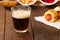 Close up of dark beer in a glass with pigs in a blanket, ketchup