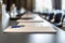 Close up of dark conference table water glasses pens, paper sheets and blurry window background