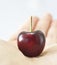 A close up of dark red cherry on blurred hand and white background