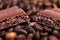 Close-up of dark roasted coffee beans and chocolate background. Aromatic coffee grains and sweet choco pieces macro photography